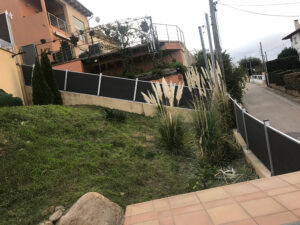Dark grey/black Mecofence WPC boundary fence following the natural slope of a residential garden in Austin, Texas, offering a low-maintenance and stylish perimeter for US-based constructors and wholesalers.