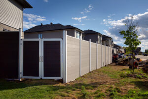Light grey Mecofence WPC privacy fence featuring a contrasting dark double gate, providing secure, durable access solutions for new residential construction projects and bulk buyers.