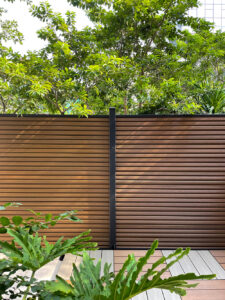 Close-up of a modern brown Mecofence WPC privacy fence panel with horizontal lines, providing premium, weather-resistant boundary solutions for overseas constructors and retailers import to USA