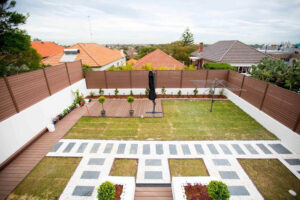 Elevated view of a brown Mecofence WPC boundary fence enclosing a residential backyard, delivering scalable and durable property line solutions for global wholesalers.
