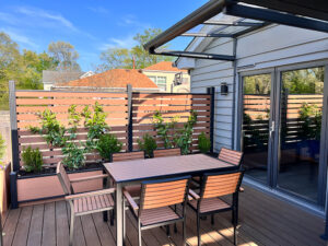 Brown horizontal slatted Mecofence WPC fence providing semi-privacy for an outdoor patio space, ideal for commercial and residential bulk projects overseas.