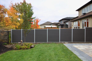 Dark grey Mecofence WPC privacy fence enclosing a suburban backyard, offering durable and low-maintenance boundary solutions for global residential constructors.