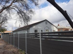 Dark grey Mecofence WPC semi-privacy fence with an aluminum frame, providing modern and durable boundary solutions for residential constructors and overseas wholesalers.