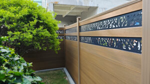 Brown Mecofence WPC fence featuring custom decorative metal panels, offering stylish and durable boundary solutions for global commercial constructors.