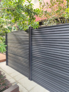 Dark grey Mecofence WPC louvered privacy fence, providing modern and low-maintenance boundary solutions for commercial constructors and global wholesalers.