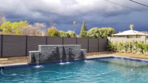 Dark grey Mecofence WPC privacy fence for pool areas, offering moisture-resistant boundary solutions for global residential constructors.