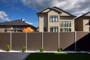 Solid brown WPC composite privacy fence with modern metal posts installed in a residential backyard setting