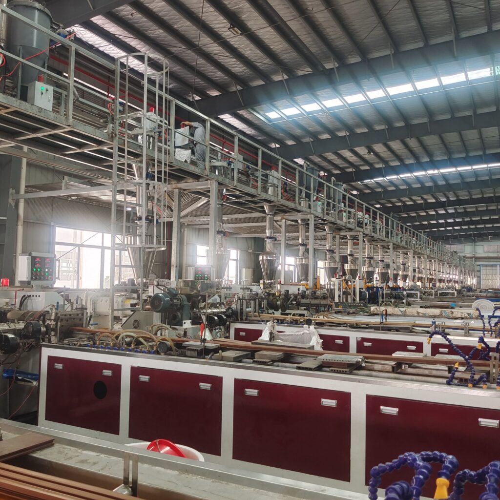Long **automated production lines** in MecoFence factory, showcasing the **high-volume manufacturing** capacity for **WPC composite fence panels**.