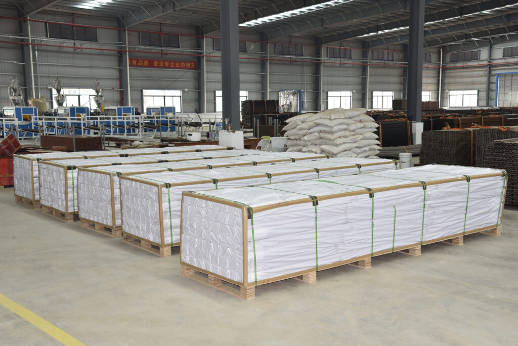 Palletized and securely shrink-wrapped composite fence panels in warehouse, confirming **export readiness** and professional handling for large **B2B orders**.