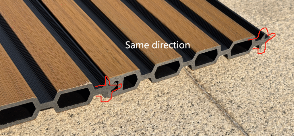 Close-up cross-section of Mecofence fluted composite fence panel, displaying the hollow core interior and the tongue-and-groove interlocking edges designed for seamless vertical stacking.