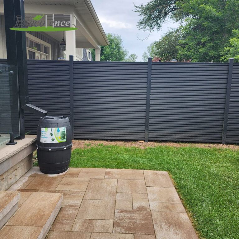 drak grey slat composite fence in backyard