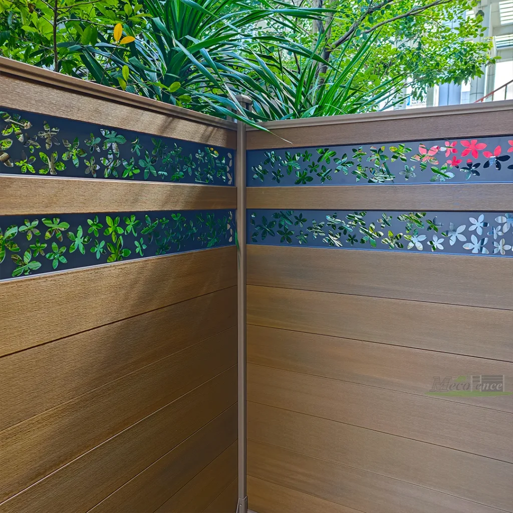 Corner installation of Teak woodgrain composite fencing with floral aluminum screens