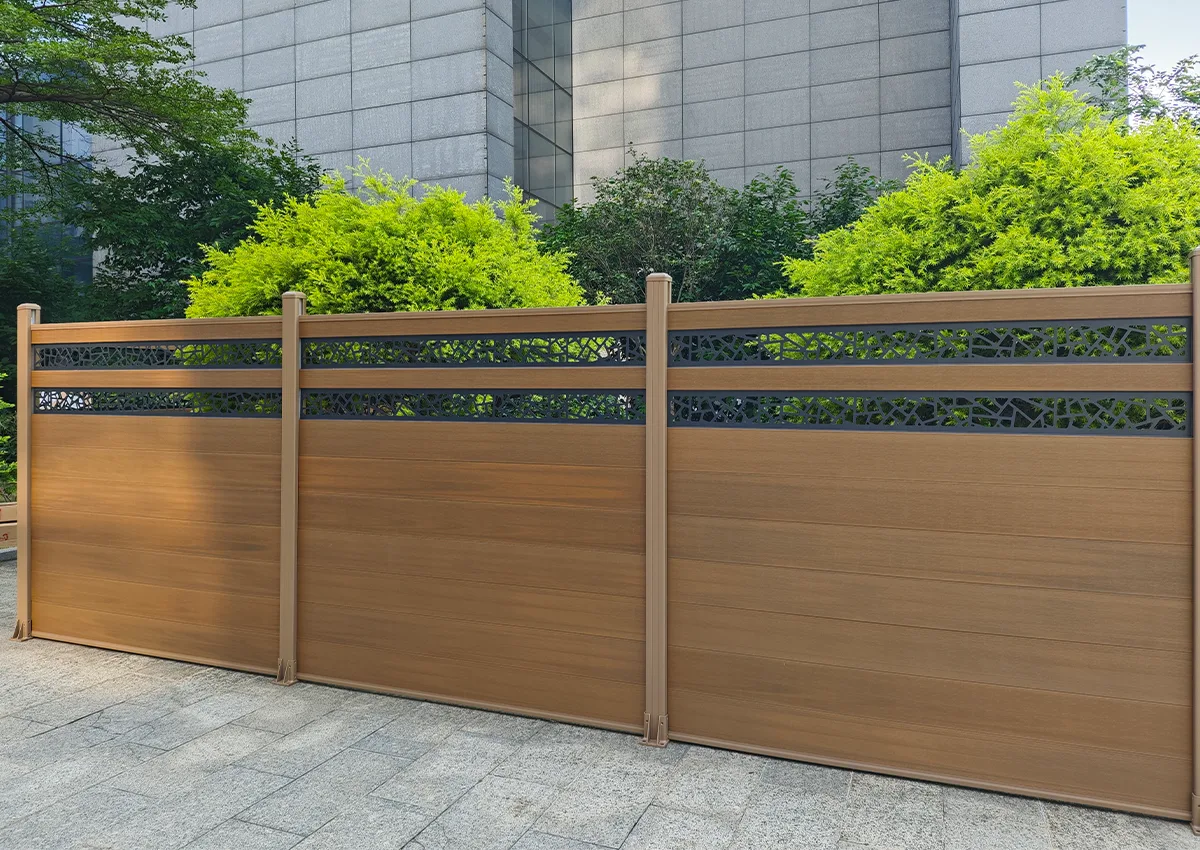 Long run of woodgrain composite fencing with decorative aluminum top screens
