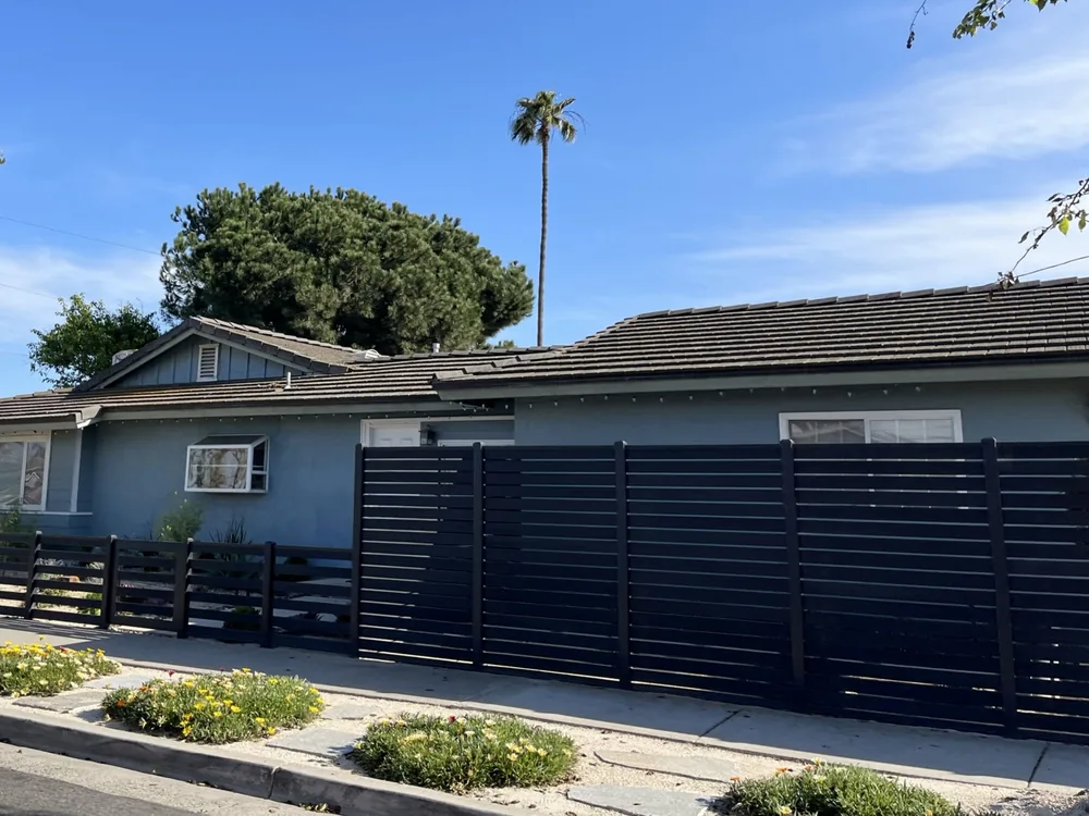 Street frontage with full-trellis composite fence and low ranch-style section