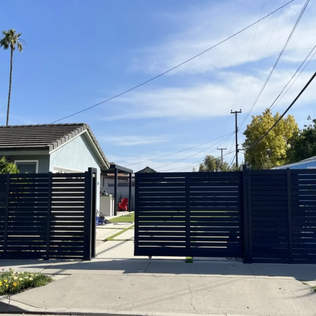 Full-trellis composite sliding gate on an aluminium track beside a fence run
