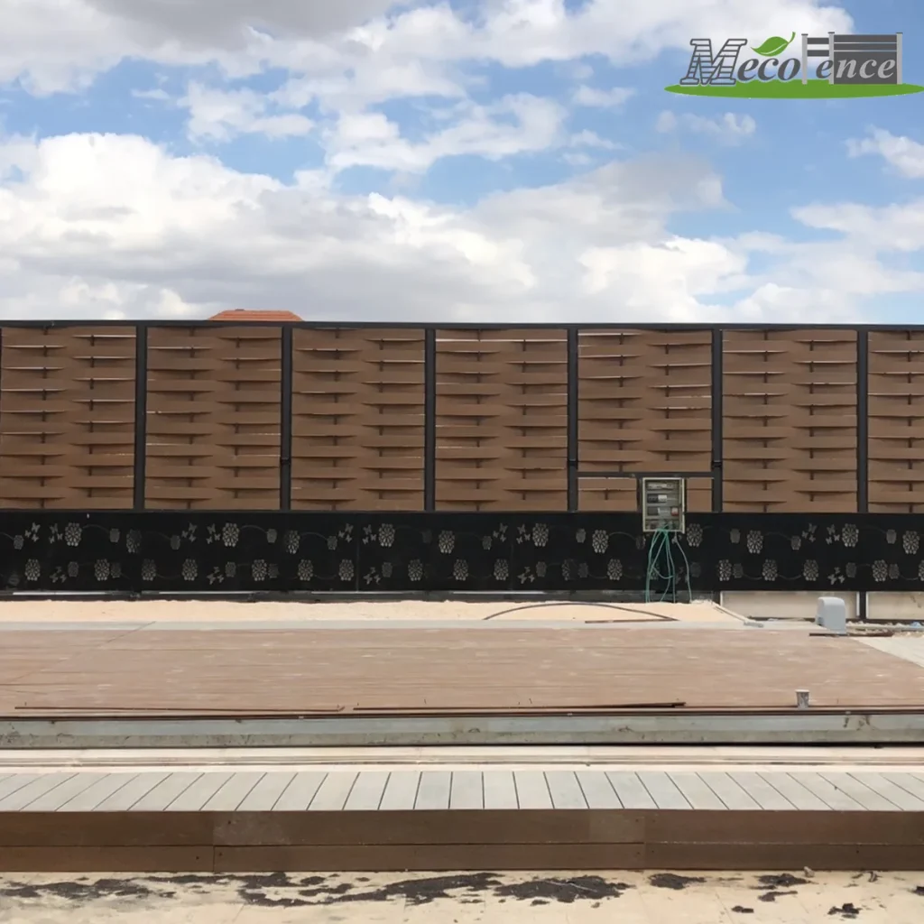 Brown woven composite fence installed above a decorative carved fence base along a composite deck