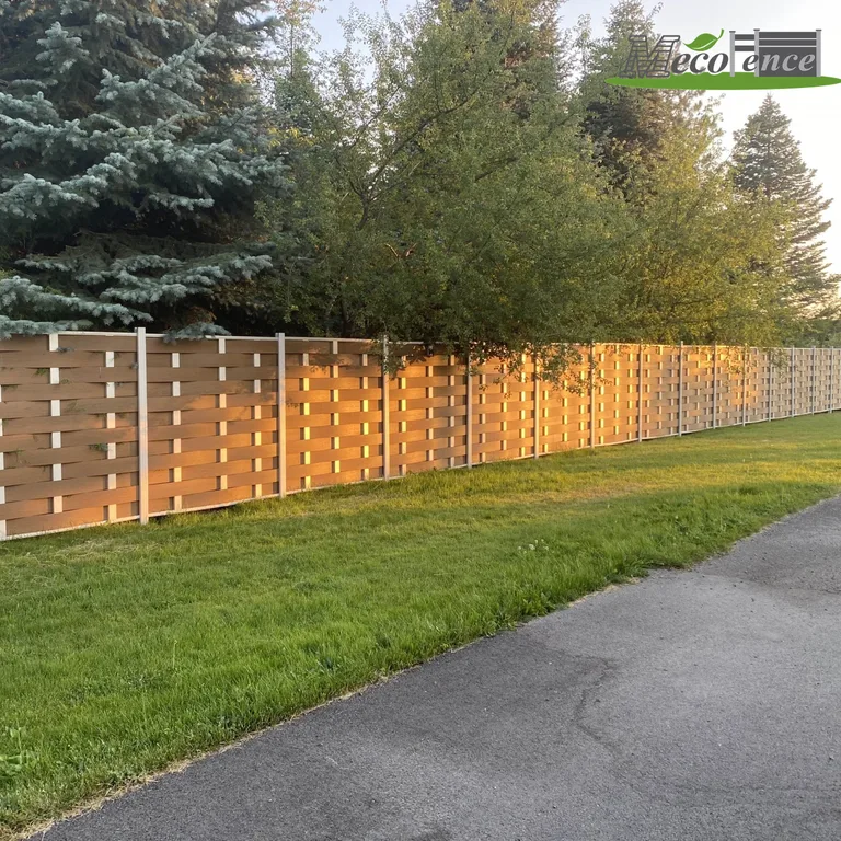Customer-installed teak woven composite fence with daylight filtering through the weave beside a solar street light