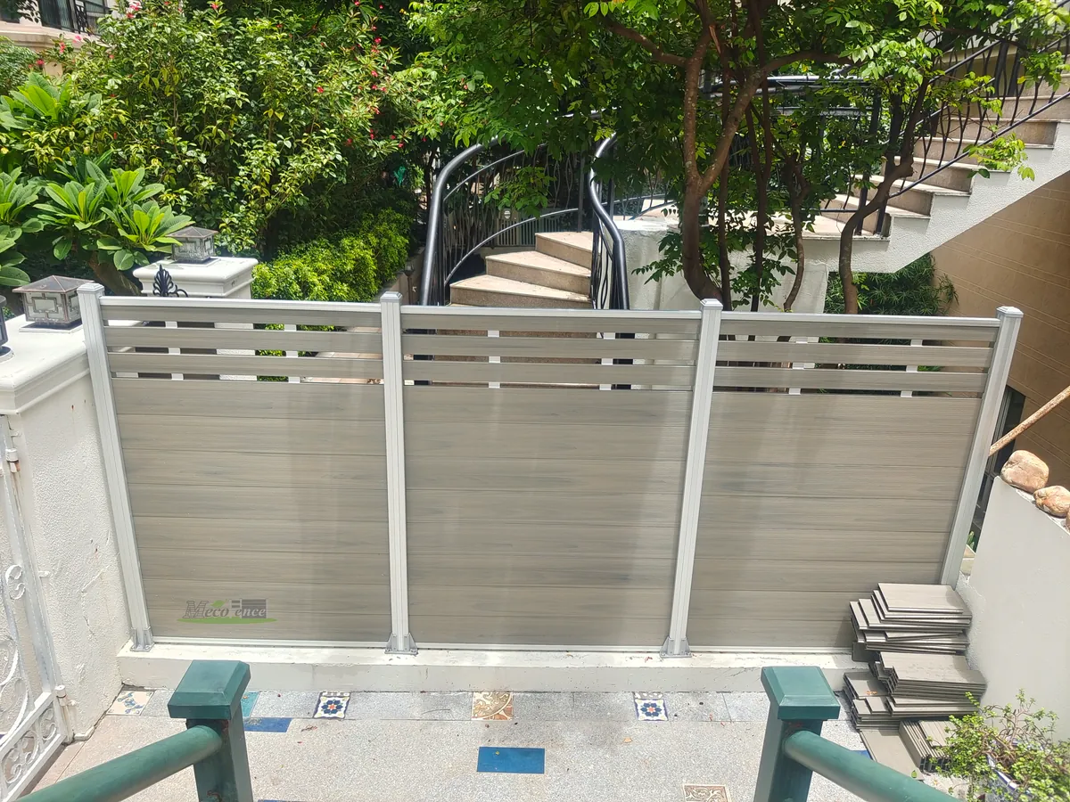 Ashwood Mid-Trellis Composite Fence panels with silver aluminium posts in a residential courtyard