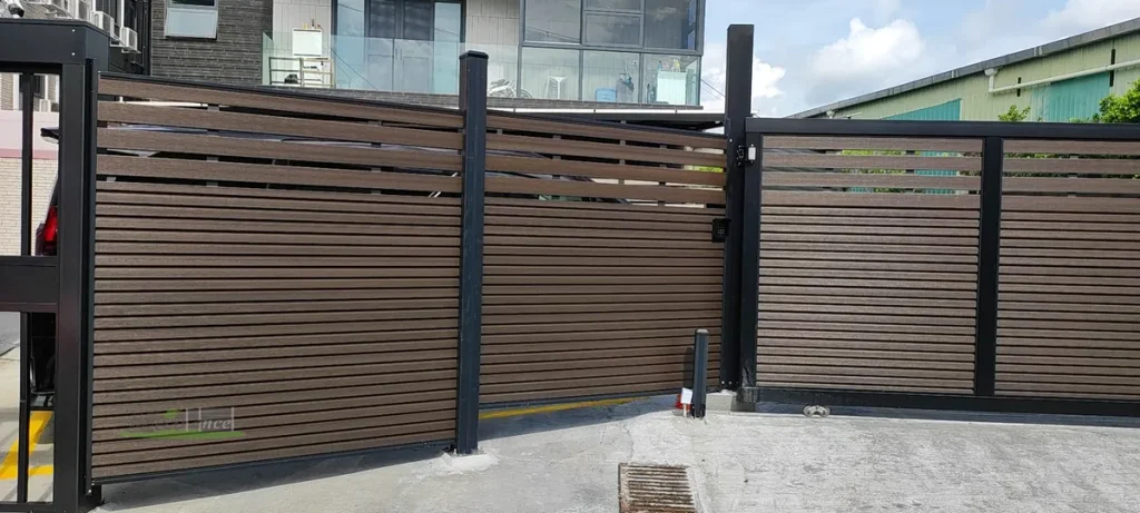 Walnut Mid-Trellis Composite Fence with matching slide gate at a driveway entrance