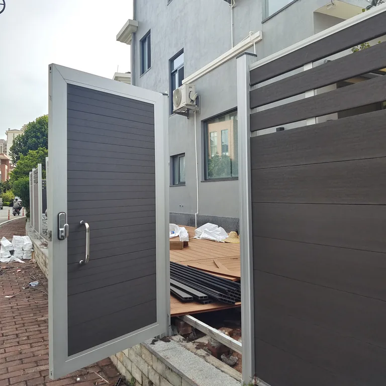 Dark grey privacy single-leaf gate shown open at a building entrance