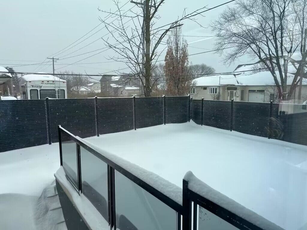 Close-up of composite or wood fence panels covered in snow and ice