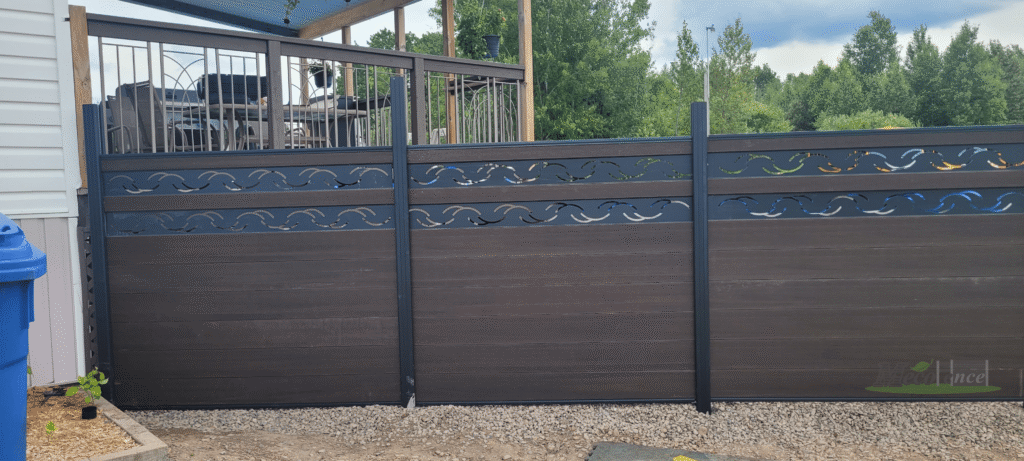 dark brown composite privacy fence panel featuring a unique decorative wave pattern cutout section at the top, installed adjacent to a house deck in Canada