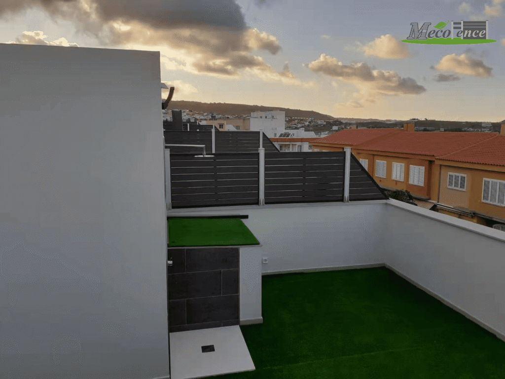 Rooftop patio renovation featuring 4ft antique composite privacy fencing and artificial grass, overlooking a residential neighborhood.