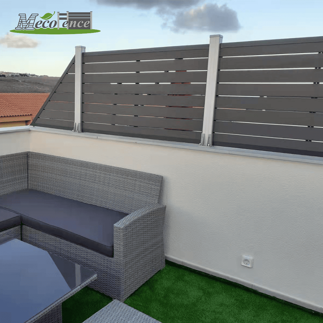 Mecofence 4ft antique color composite trellis fencing mounted on a white stucco balcony wall, providing privacy behind grey wicker patio furniture and artificial grass flooring