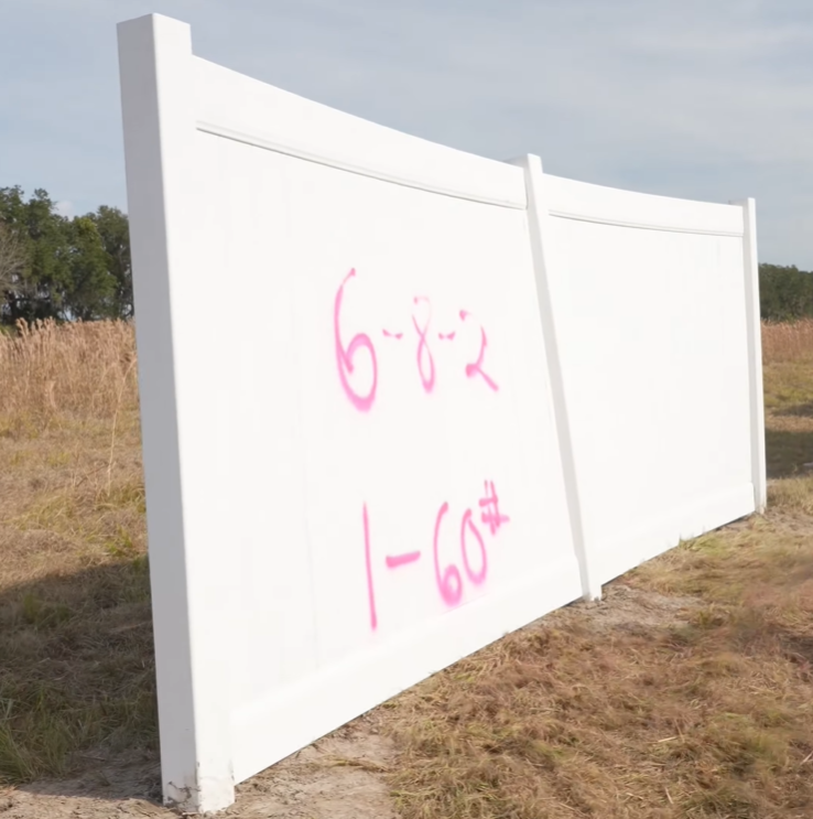 Field test showing a standard 6*8ft vinyl fence post kinking at the base under 60-75 mph simulated hurricane winds generated by an airboat before