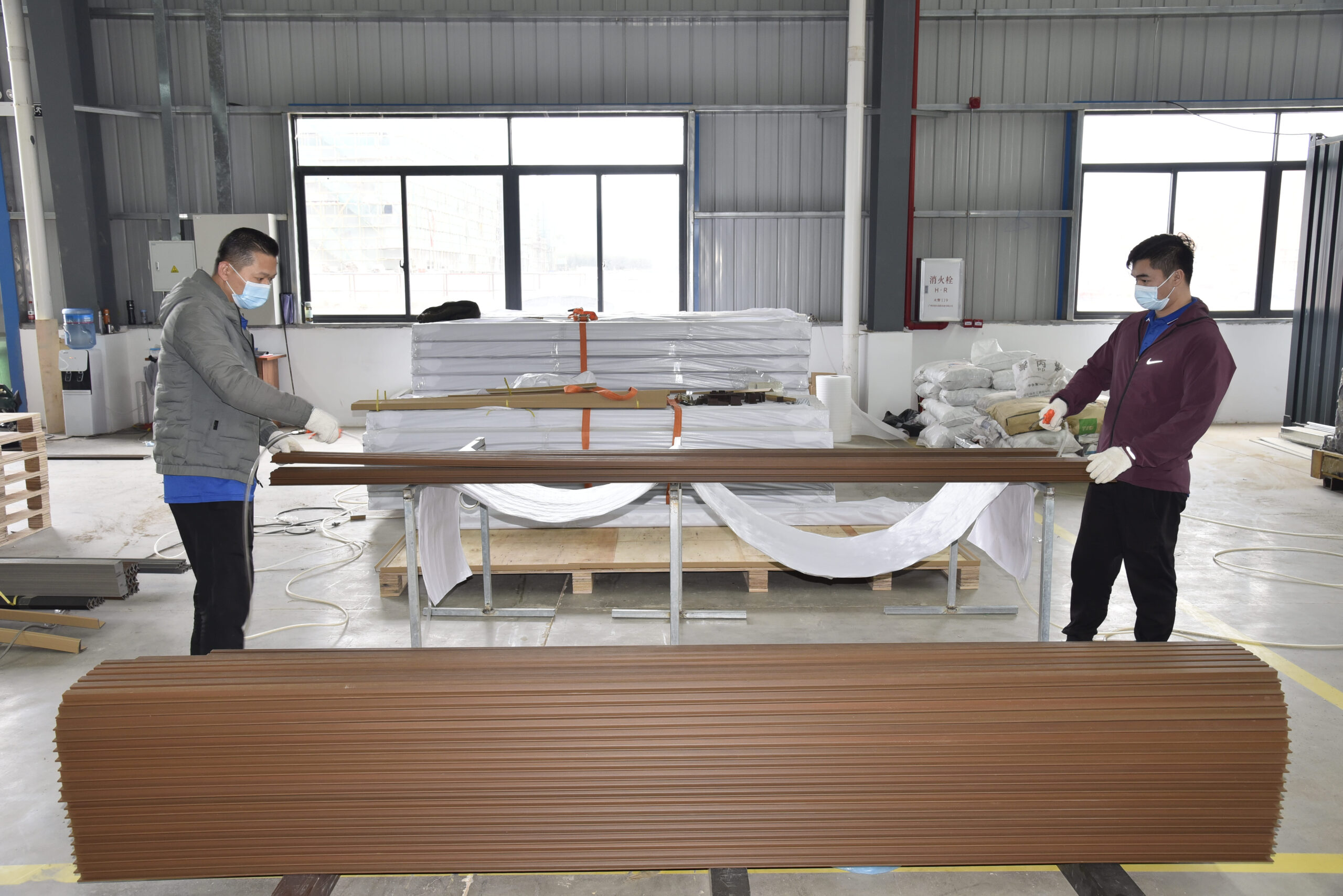 MecoFence workers packing WPC fence panels with protective packaging for export