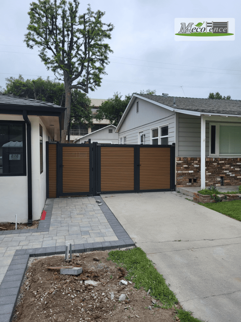 Finished teak fluted composite fence double swing driveway gate at California residence