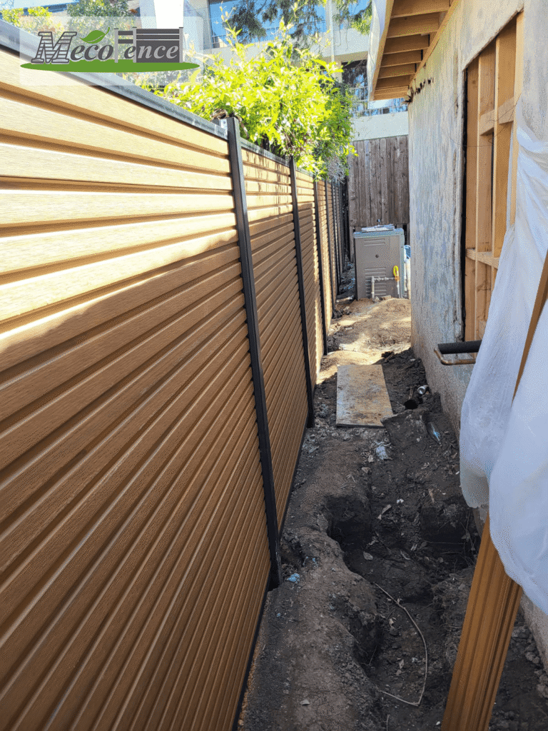Finished horizontal teak fluted composite fence panels in tight residential side yard