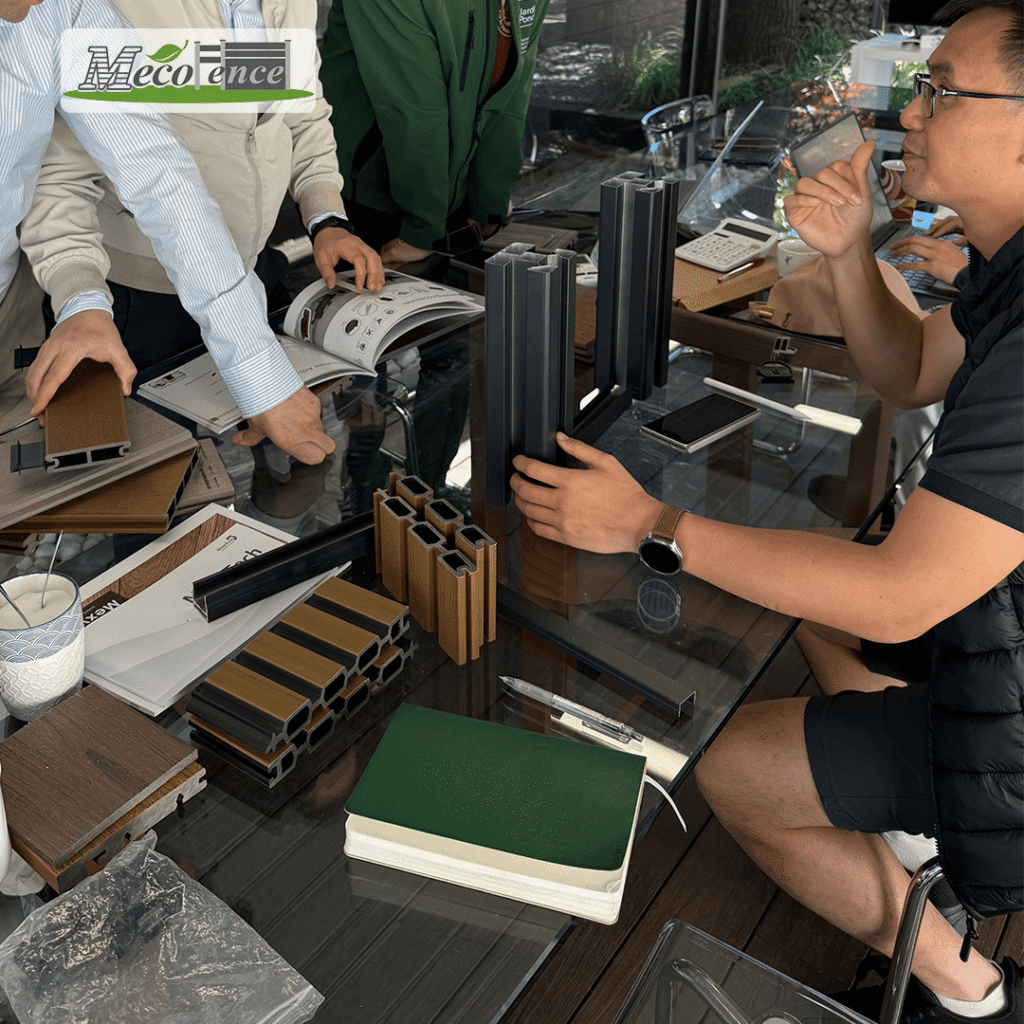MecoFence team presenting co-extrusion composite fence board samples and aluminum post profiles during a European distributor meeting in 2026