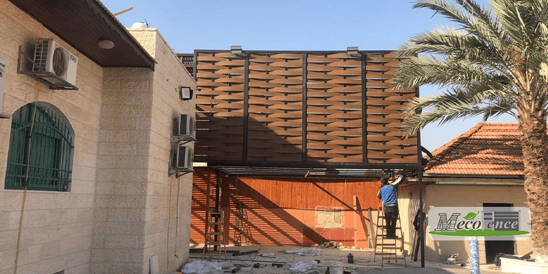 MecoFence composite slat fence installation on a hot-climate project in Israel, mid-installation in desert sunlight