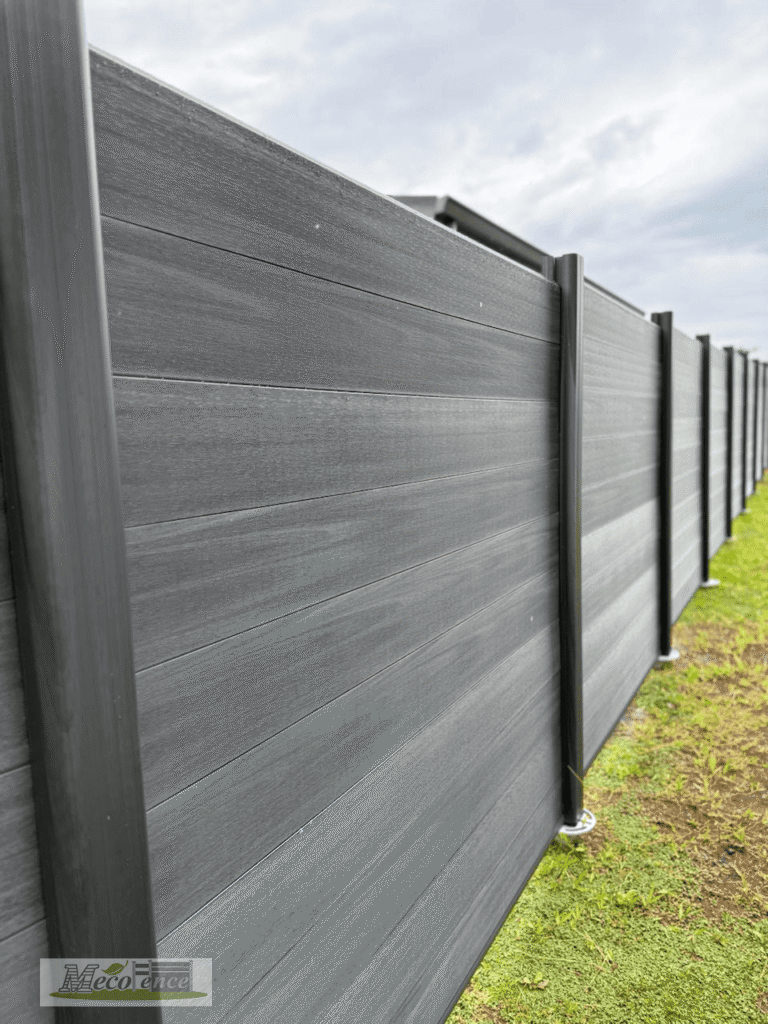 Close-up of Dark Grey 360-degree co-extruded WPC fence boards with natural wood-grain texture between WPC posts
