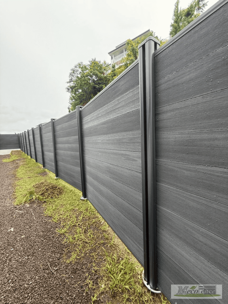 Dark Grey co-extruded WPC fence post and board running along a curved hillside path in French Polynesia