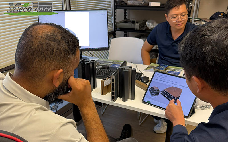 MecoFence team reviewing dual-tone composite fence samples during a face-to-face B2B meeting.