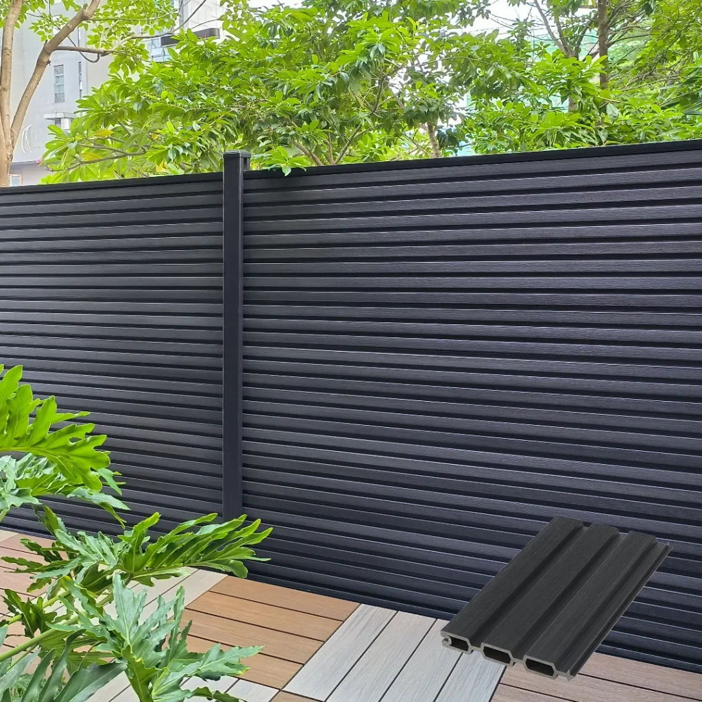 Dark grey fluted composite fence panels installed horizontally with black aluminum posts