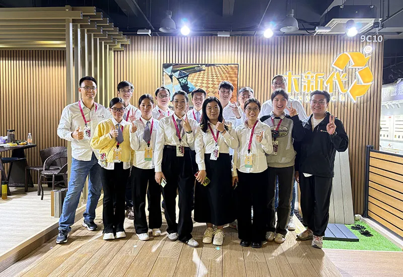 MecoFence team photo taken at the Guangzhou Designer Week exhibition booth showcasing composite fencing products.