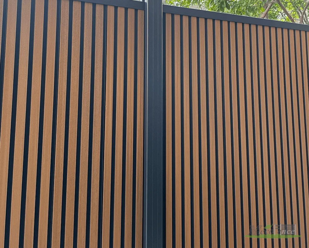 Installed dual-tone composite fence with vertical wood-tone fluted, black grooves and a dark frame