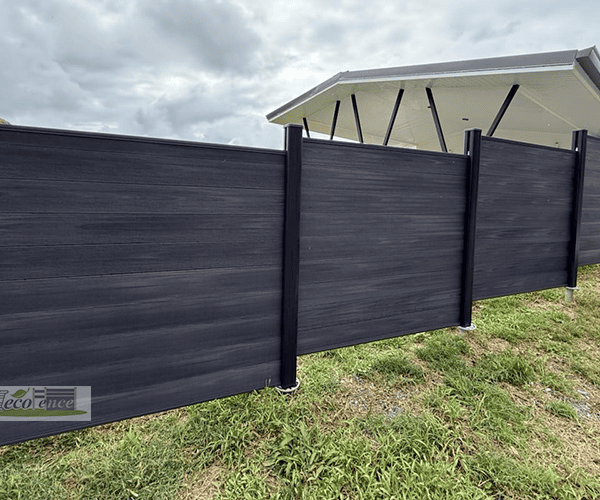 Dark Grey WPC fence panels stepping up a grassy hillside slope in French Polynesia